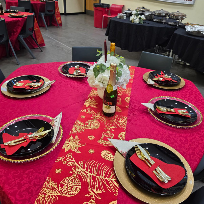 Festive table setting with gold chargers and black plates